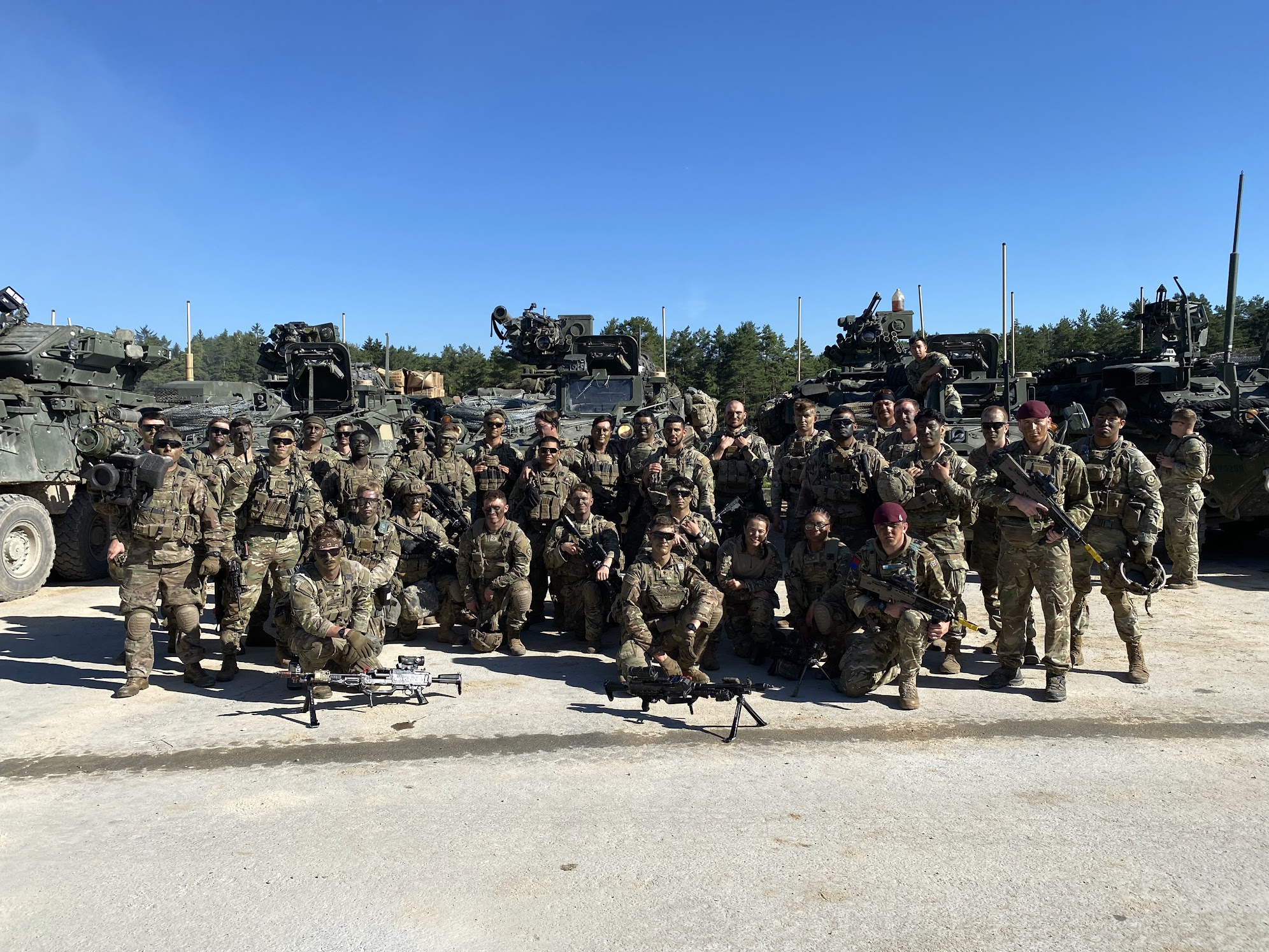 Soldiers gathered in front of armored vehicles in Hohenfels, Germany